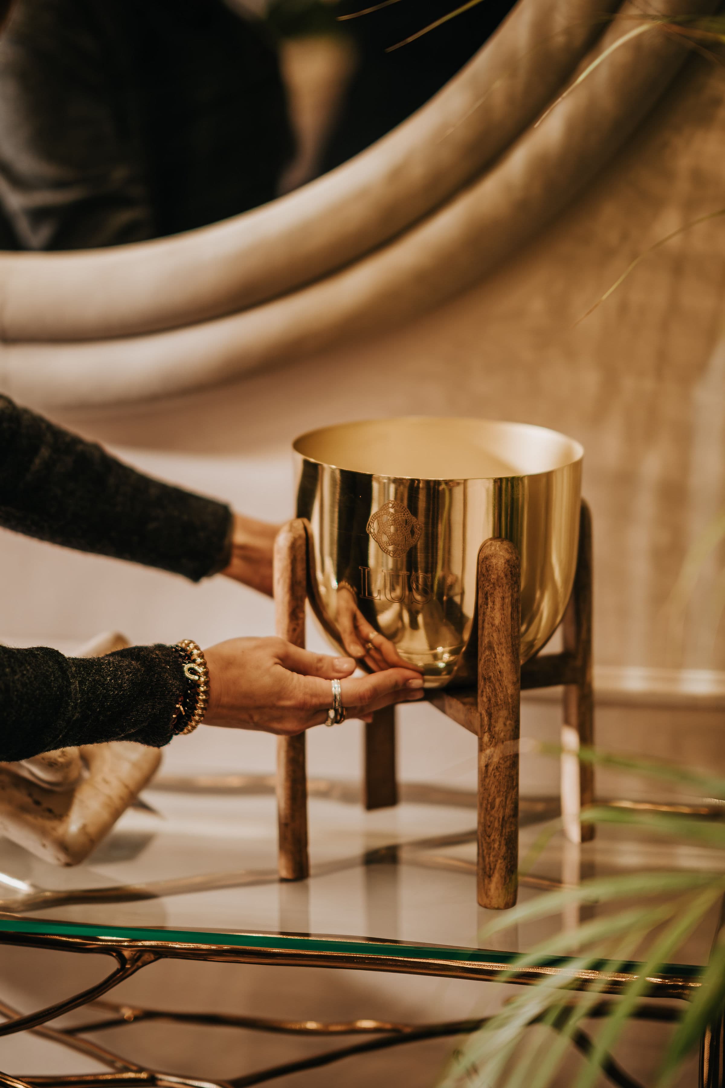Mãos a segurar uma grande taça LUS em latão dourado